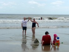 Jeff and Daria on the beach with Adam and Isis playing in the sand