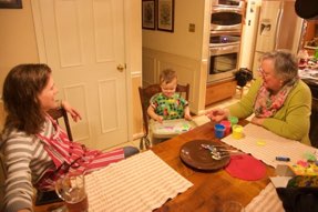 Sarah and Daria watch as Jacob finger paints